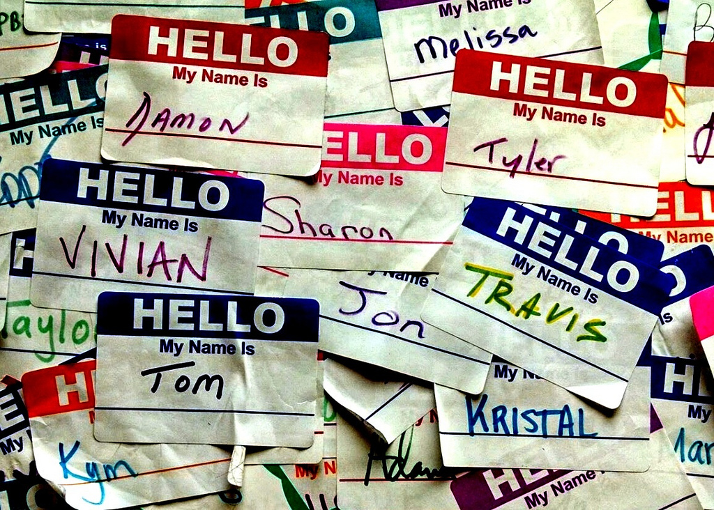 Photo of a lot of “Hello, My name is” stickers with various names and many of them overlapping. Photo by Travis Wise on Flickr.